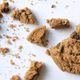 Chocolate chip cookie crumbled on white surface